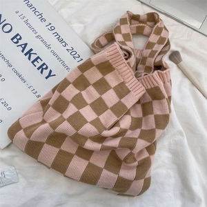 Detail of knit checkerboard tote bag with pink and brown woven pattern texture