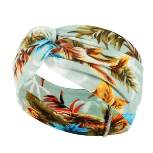 Detail shot of the mint green yoga headband with tropical leaf patterns and front knot