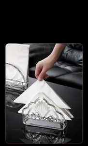 Detail of elegant fan-shaped crystal glass napkin holder with shell texture on dark base