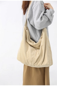 Detail of beige corduroy shoulder bag showing fabric texture and large capacity fit