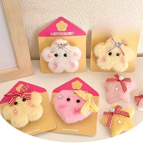 Close-up of plush star and heart hair clips with cute faces and plaid bow details