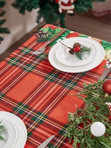 Detailed Christmas table runner featuring red plaid with pine cones and holly berry patterns
