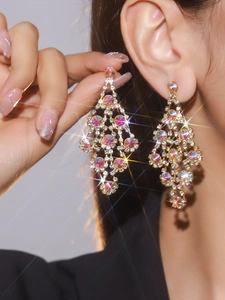 Detailed view of luxury long gold tassel earrings with colorful sparkling rhinestones