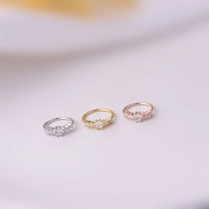 Three nose rings in silver, gold, and rose gold finishes with five inlaid zircons