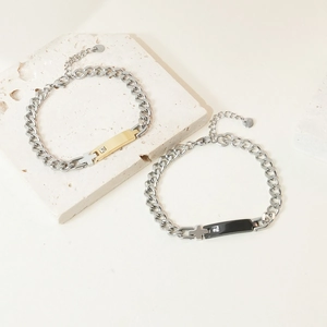Detail of stainless steel couple bracelets with cross pendant and zircon on stone