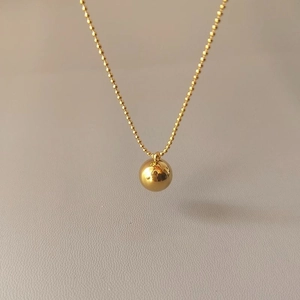 Halskette aus Titanstahl mit goldenem Kugelanhänger und feiner Gliederkette für Damen