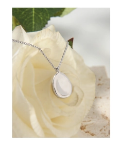 Close-up of minimalist S925 sterling silver oval pendant on a delicate white rose petal