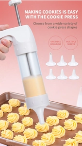 Detail of using a clear cookie press with white nozzles to create star-shaped biscuits