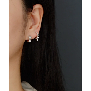 Close-up of S925 sterling silver drop earrings with diamonds worn on model's ear