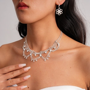 Silver teardrop floral rhinestone necklace and earrings set worn by a female model