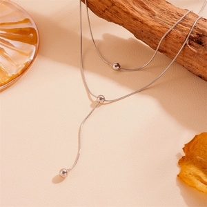 Vue détaillée d'un collier double rang en acier inoxydable avec pendentifs perles.