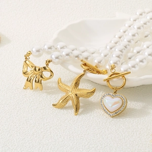 Detail of vintage gold starfishes and crystal heart pendants on a pearl chain
