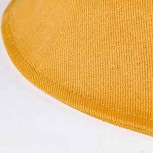 Gros plan sur le sergé de coton jaune avec coutures détaillées sur le bord du chapeau bob