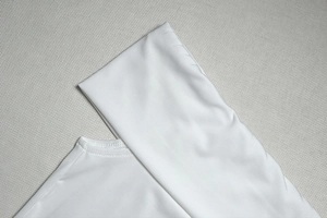 Détail du tissu en soie glacée blanche montrant les coutures de qualité et l'élasticité