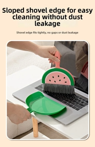 Close-up of watermelon-shaped mini broom cleaning laptop keyboard with a green dustpan