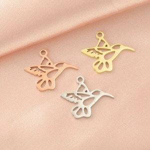 Polished stainless steel hummingbird pendants in gold, rose gold and silver on pink silk