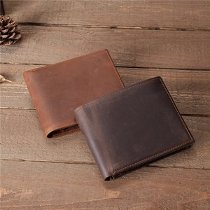Detail of vintage leather wallets in dark and light brown on a rustic wood background