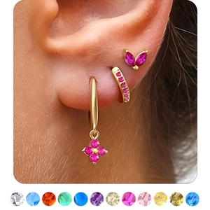 Detail of gold birthstone earrings set featuring floral charms and multiple gem colors