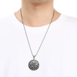 Close-up of a vintage silver Nordic wolf and eagle pendant on a square link chain