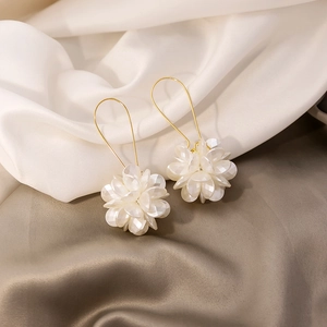 Exaggerated long white floral petal earrings with golden geometric hooks on silk
