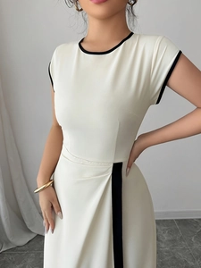 Detail of white sleeveless dress showing elegant black piping and pleated waist texture