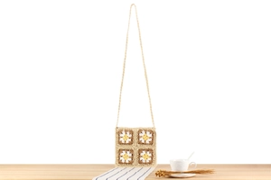 Détail d'un sac bandoulière au crochet fait main avec motifs de marguerites sur bois