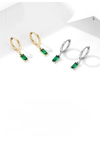 Detail view of gold and silver earrings with rectangular green zircon stone drop