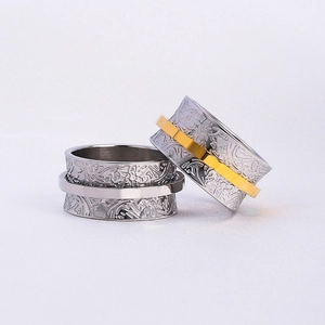Close-up of vintage wide band spinning rings with floral relief patterns and rotating gold inlay