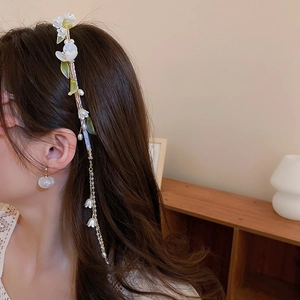 Detail view of lily of the valley hair clip with long pearl tassels on female model
