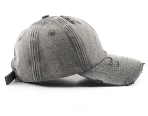 Side view of gray washed cotton baseball cap with vintage distressed holes and curved brim