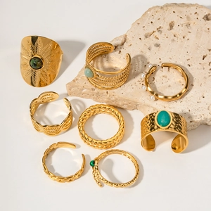 Bohemian gold ring set with turquoise and malachite stones on light decorative rocks