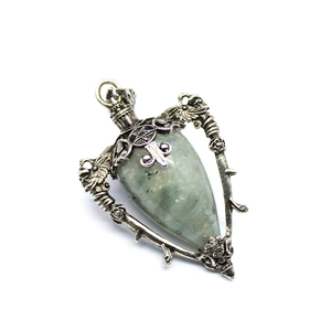 Macro detail of silver necklace with labradorite stone, pentagram and cross carvings