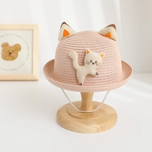 Détail d'un chapeau de paille rose pour enfants avec oreilles de chat en 3D et patch
