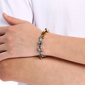 Close-up of men's mixed-metal bone chain bracelet with gold and silver color tones