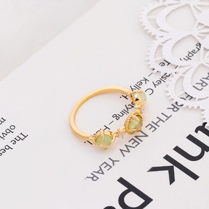 Close-up of gold-plated silver ring with green prehnite stones and small diamonds
