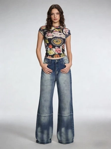Detail von Vintage-Jeans mit weitem Bein, Retro-Flügel-Druck und gewaschenem High-Waist-Stil