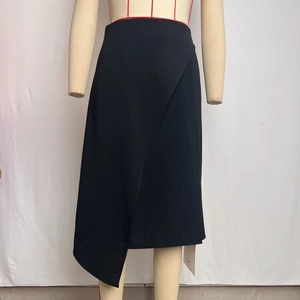 Detail view of the black asymmetrical high-waisted midi skirt with irregular hem and slit