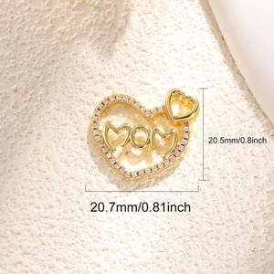 Gold heart pendant with MOM lettering and zircon inlay on beige stone background