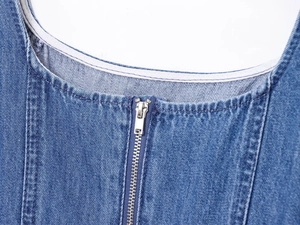 Dettaglio di abito in denim con scollatura rotonda e cerniera metallica frontale liscia