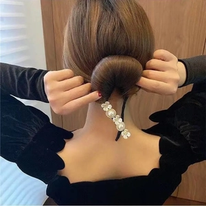 Detalle de accesorio para moños con flores y perlas usado por modelo para peinado