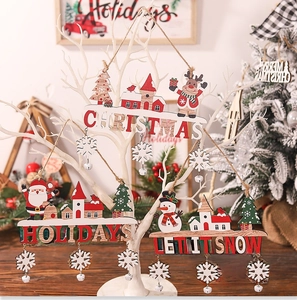 Close-up of wooden Christmas ornaments with festive lettering, snowflakes and silver bells