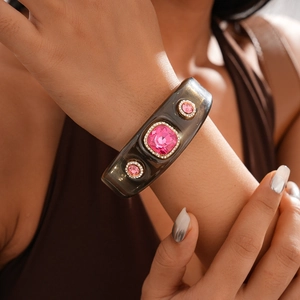 Detail of grey alloy bangle featuring pink crystal inlays with white rhinestone borders