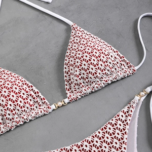 Close-up of sexy white bikini with red leopard print and golden ring pearl details