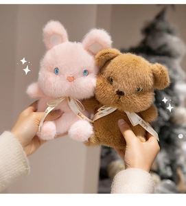 Close-up of pink bunny and brown bear plush toys with Wendy friends beige ribbons
