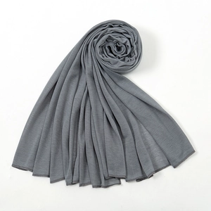 Detailed view of soft dark grey jersey fabric shawl with elegant draping and hemmed edges