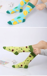 Close-up of cotton socks with lemon and avocado patterns on model feet and white sneakers