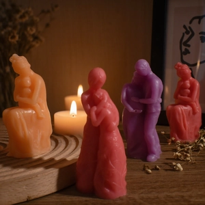 Artistic candle set with mother-child and couple figures in vibrant warm colors