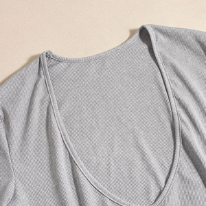 Close-up of deep V-neckline on grey ribbed knit long-sleeve bodysuit for women