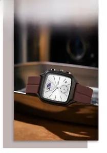 Détail d'une montre à quartz carrée avec phase de lune et bracelet en silicone marron