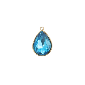 Detail of blue teardrop birthstone charm set in gold frame for DIY jewelry